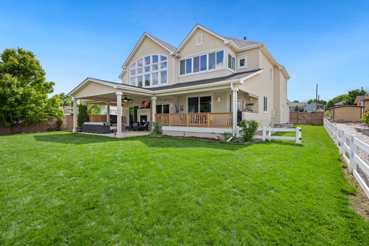 Two-story house with a covered porch and a large green lawn
