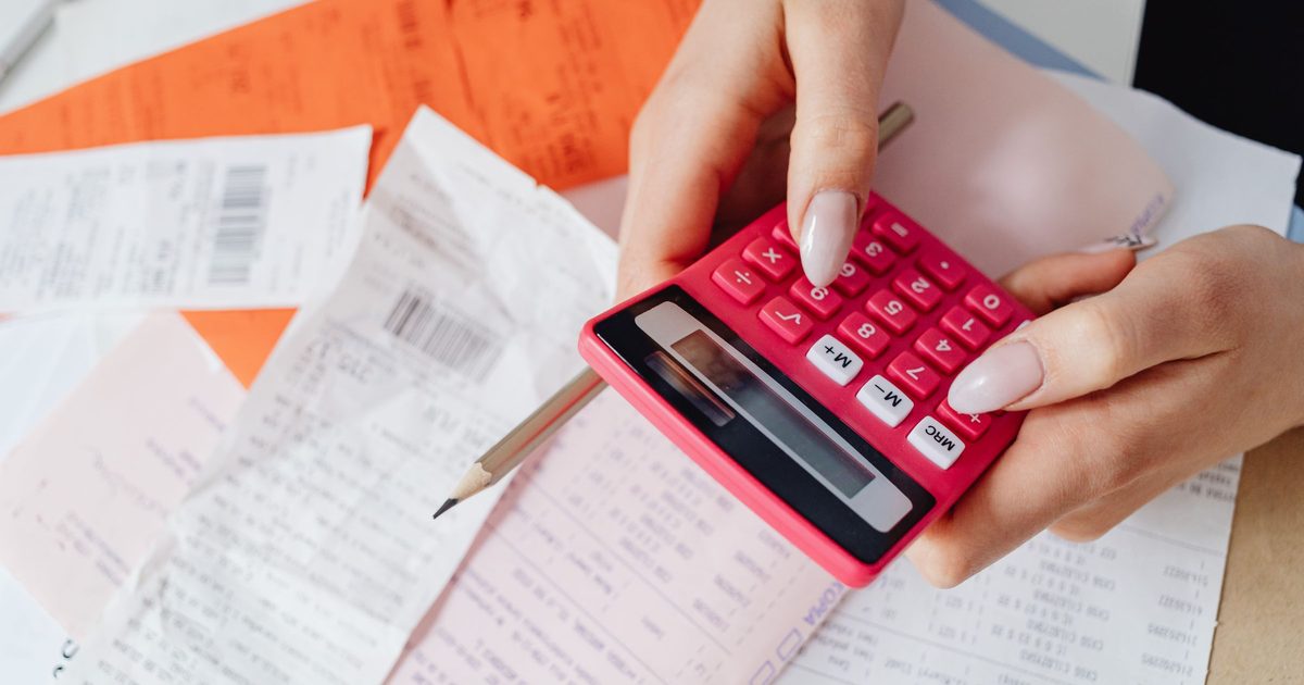 Pink calculator and receipts spread across a desk